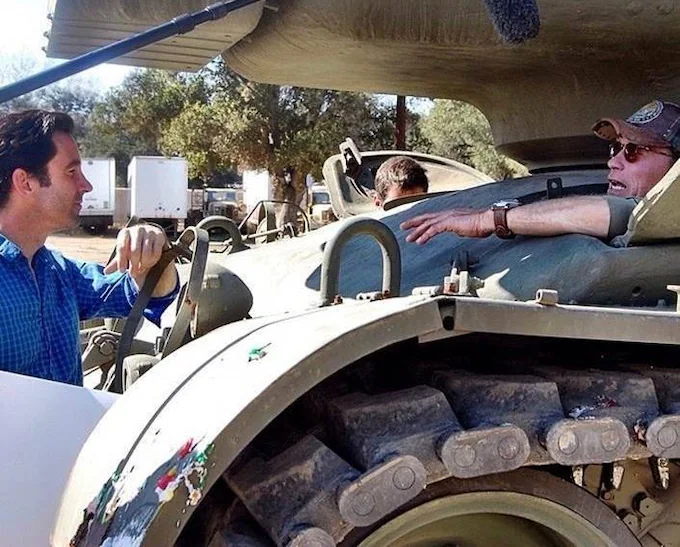 Matt Pohlson talking to Arnold Schwarzenegger in a tank